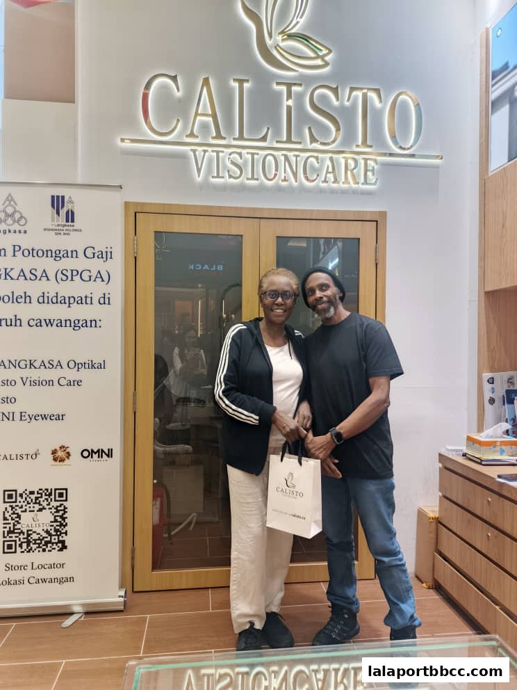 Two people stand in front of the Calisto Vision Care store entrance with a shopping bag.