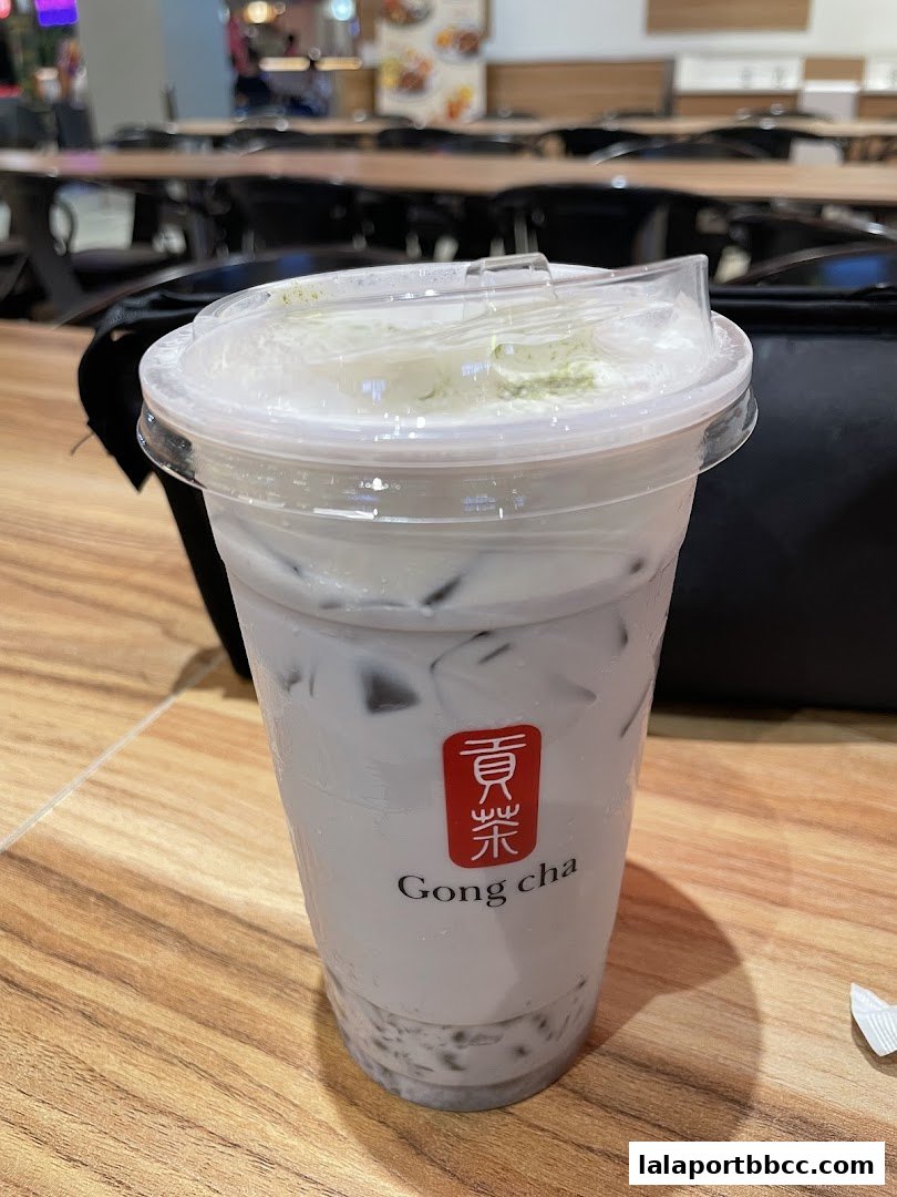 A close-up of a Gong Cha milk tea with tapioca pearls and a creamy topping.