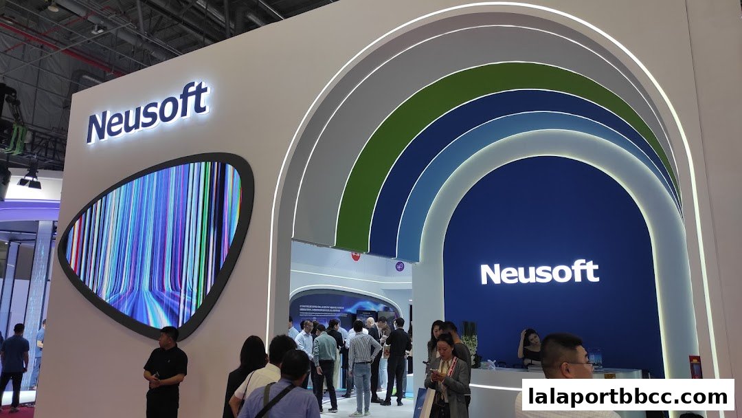 Neusoft Malaysia Sdn Bhd exhibition booth with a large screen and people interacting.