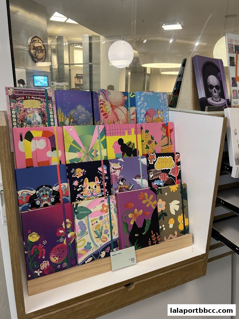 A display of colorful notebooks with various artistic designs and a price tag.