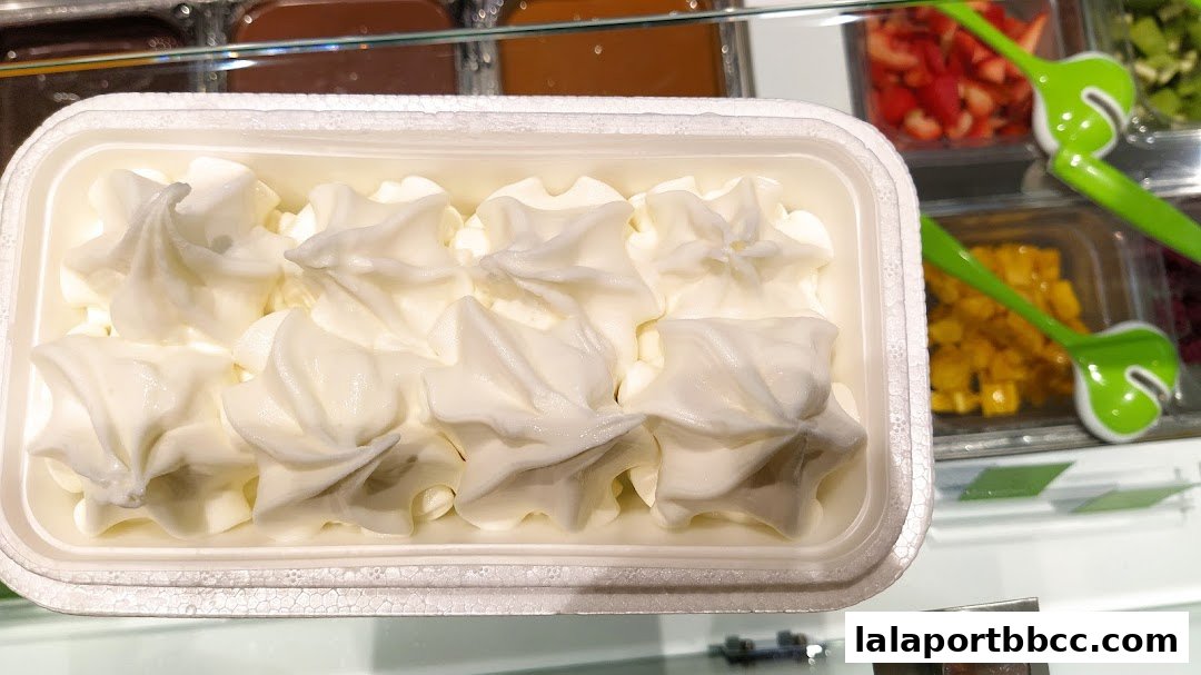 A close-up of a white frozen yogurt dessert with star-shaped swirls in a white container.