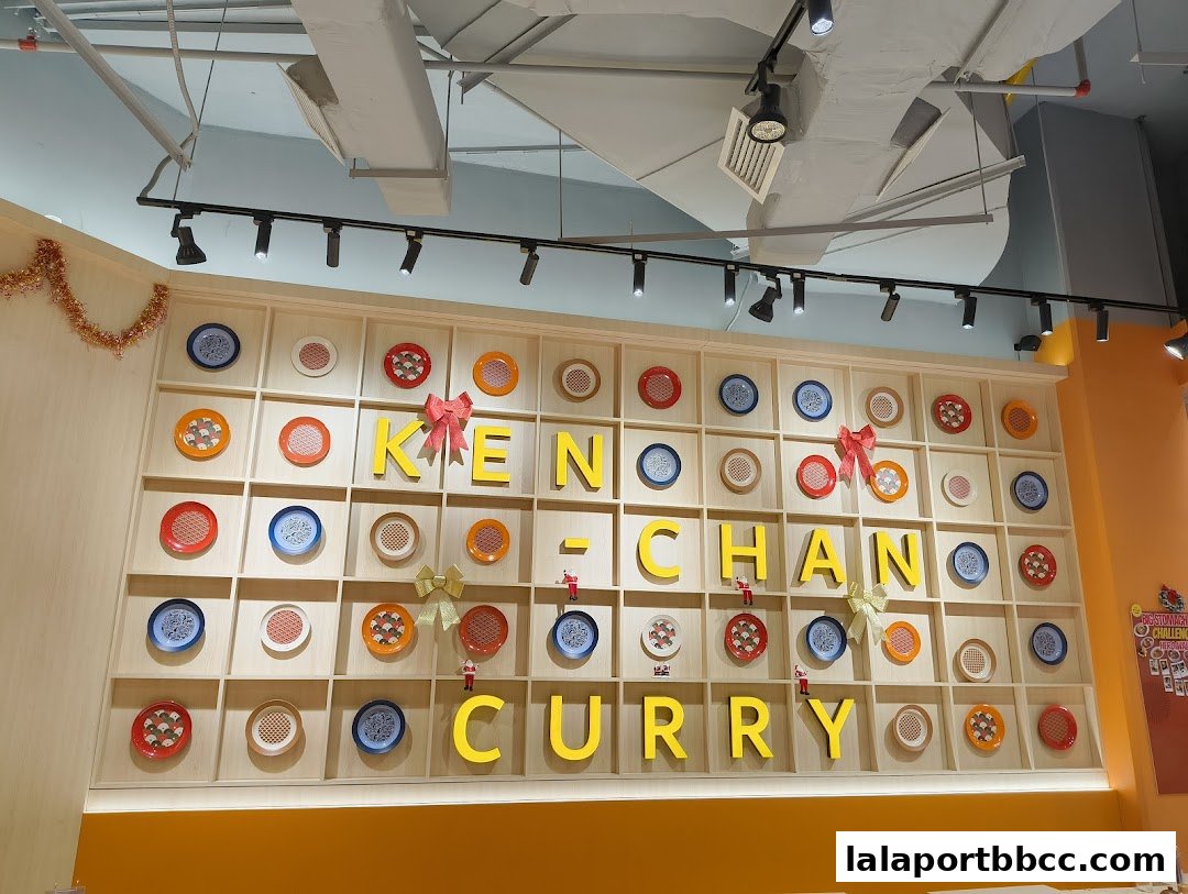 The wall of Ken-Chan Curry features large yellow letters spelling out the name, surrounded by decorative plates.