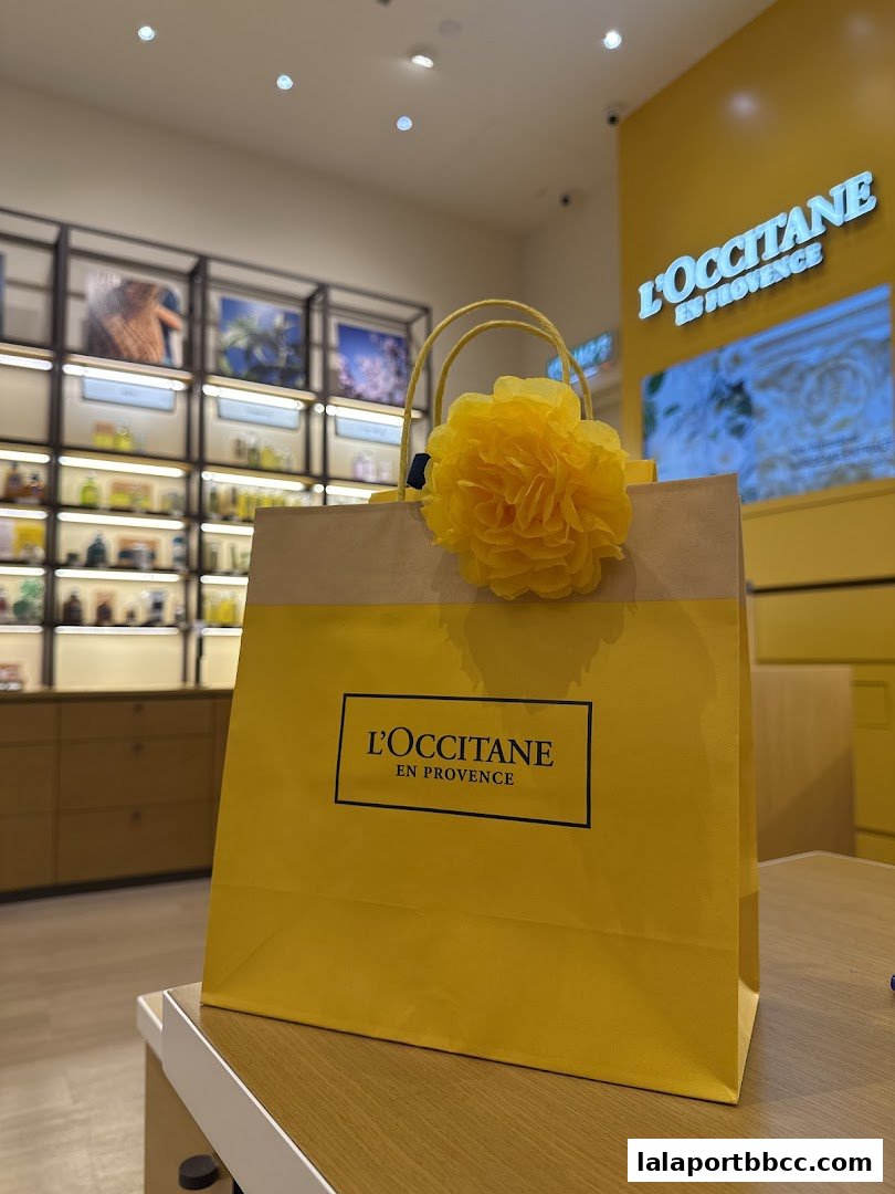 A yellow shopping bag with a yellow flower decoration from L'Occitane En Provence.