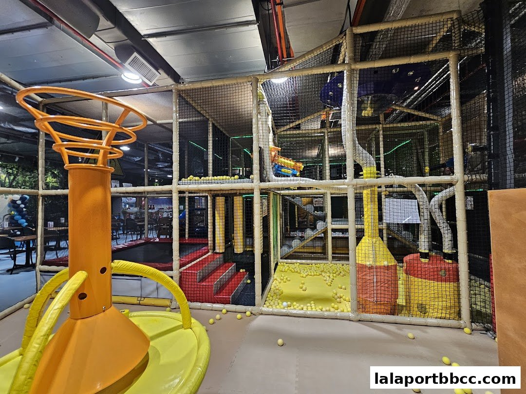 Interior of a colorful indoor playground with slides, ball pits, and climbing structures.