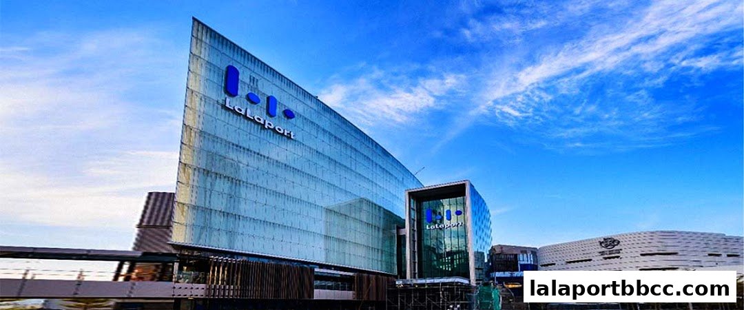 Modern glass building with LaLaport branding against a blue sky.
