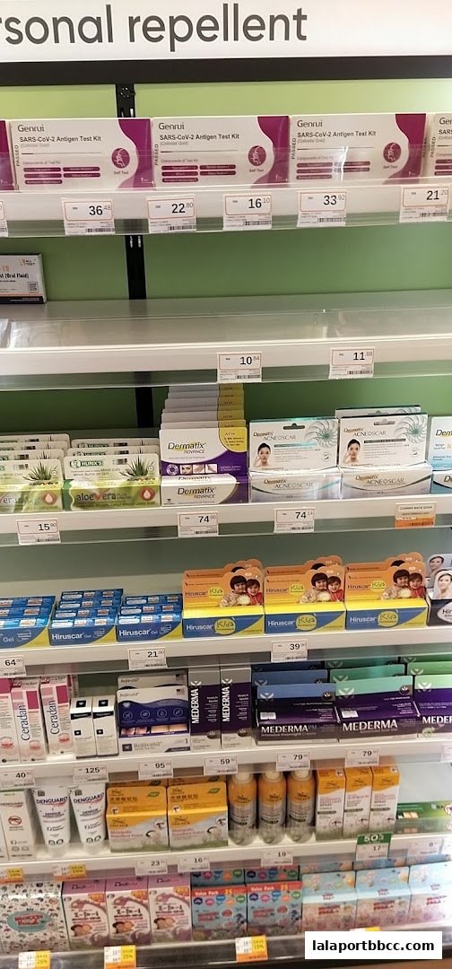 Shelves stocked with personal care products including COVID-19 test kits, scar treatments, and insect repellent.