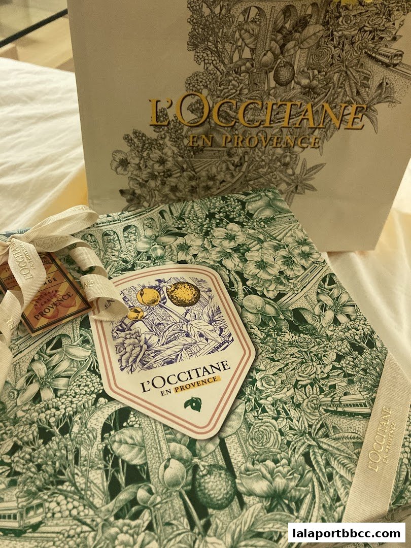 L'Occitane En Provence shopping bags with intricate floral and scenic designs.