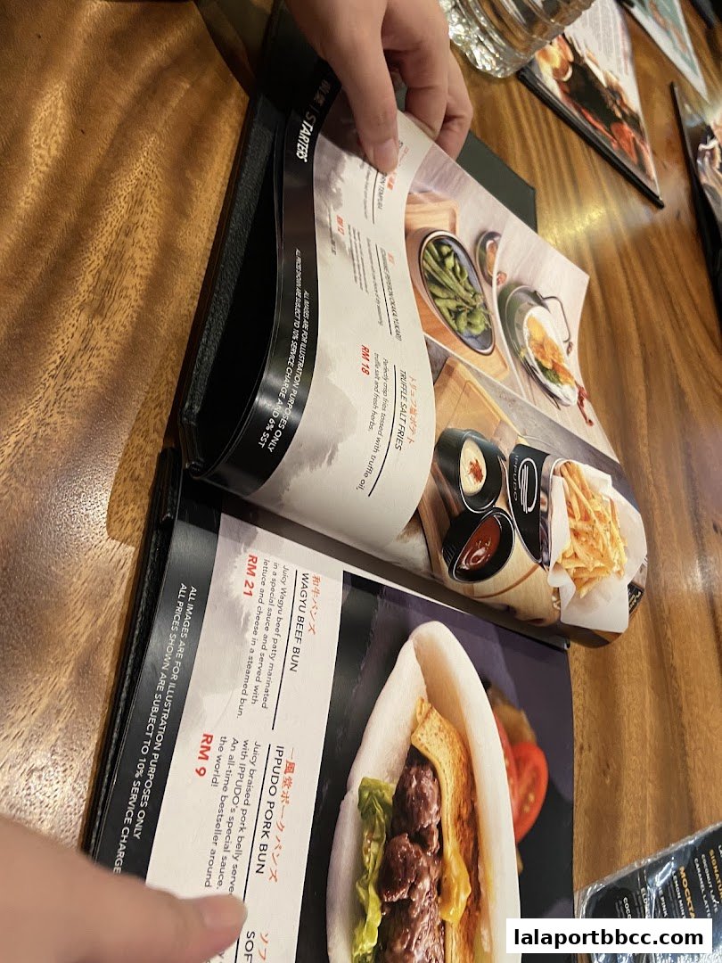 A person is looking at a menu with pictures of food items like buns and fries.