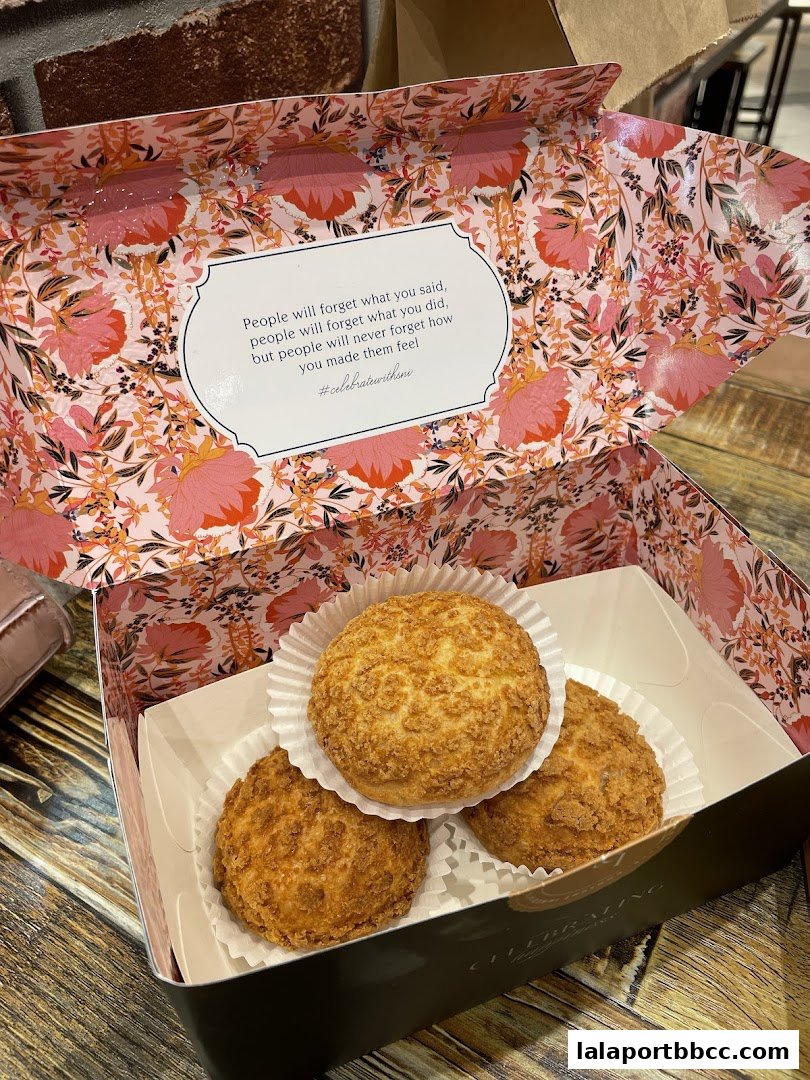 A box of cream puffs with a floral interior and an inspirational quote.