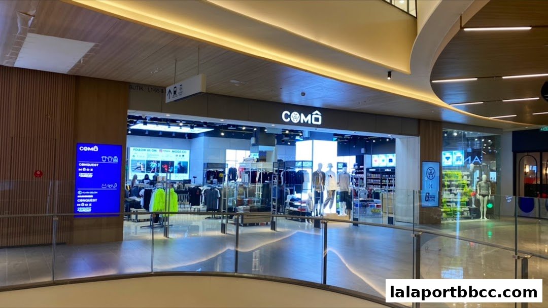 The entrance of a modern clothing store with mannequins displaying apparel.