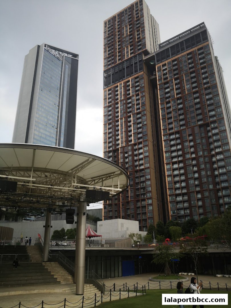 Modern skyscrapers and an outdoor amphitheater with seating and greenery.