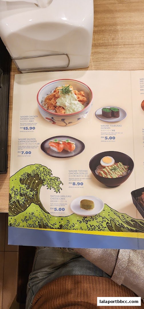A menu from Sushi King Lalaport BBCC featuring various Japanese dishes like chicken don, salmon sushi, and matcha cheesecake.