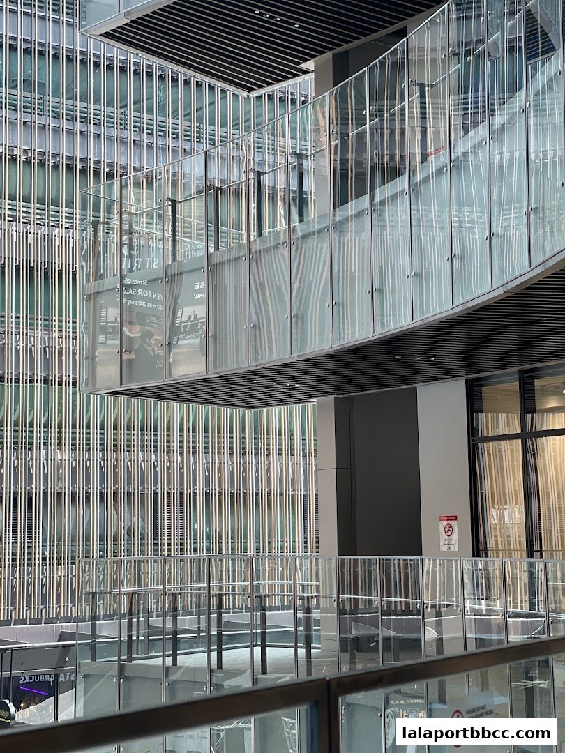 Modern architectural interior with glass walkways and vertical metal accents.