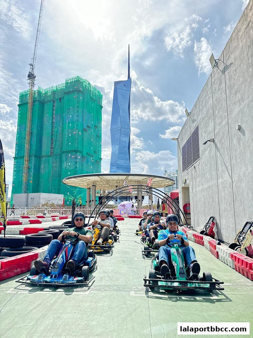 People enjoying go-karting on a sunny day with city skyscrapers in the background.