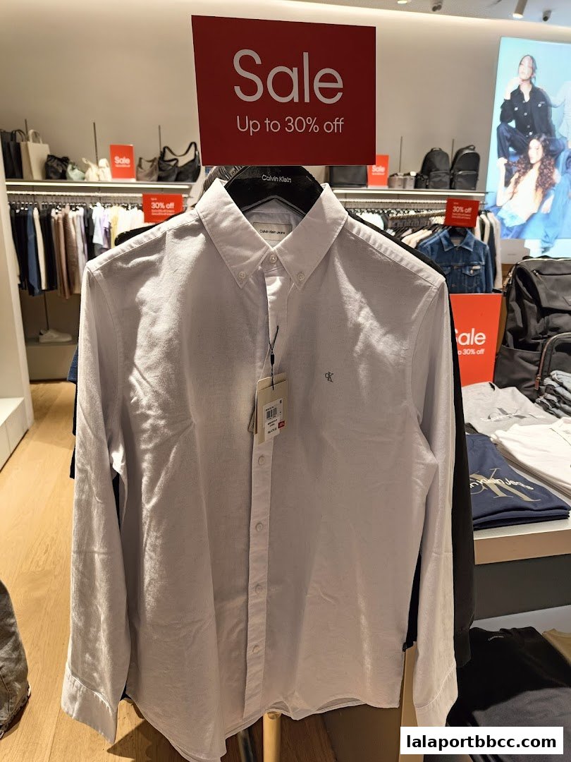 A white Calvin Klein shirt is displayed with a 'Sale Up to 30% off' sign.