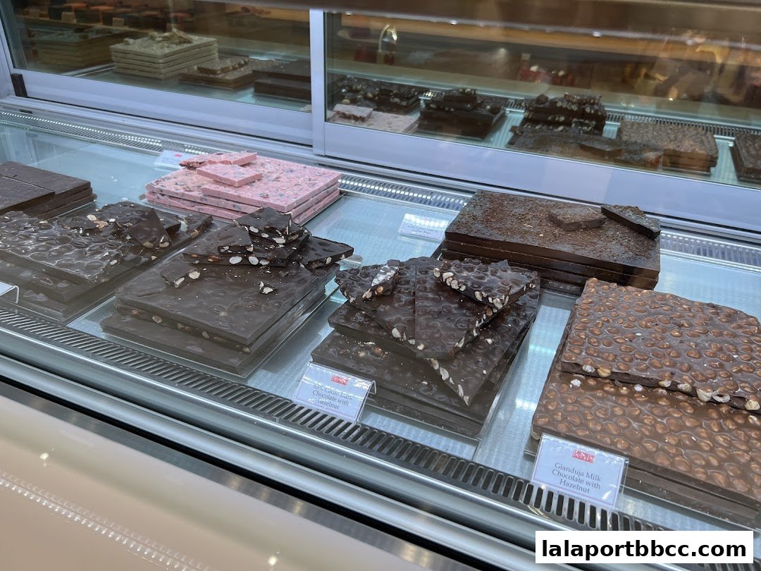 A display case filled with various artisanal chocolate bars, some with nuts and fruit.