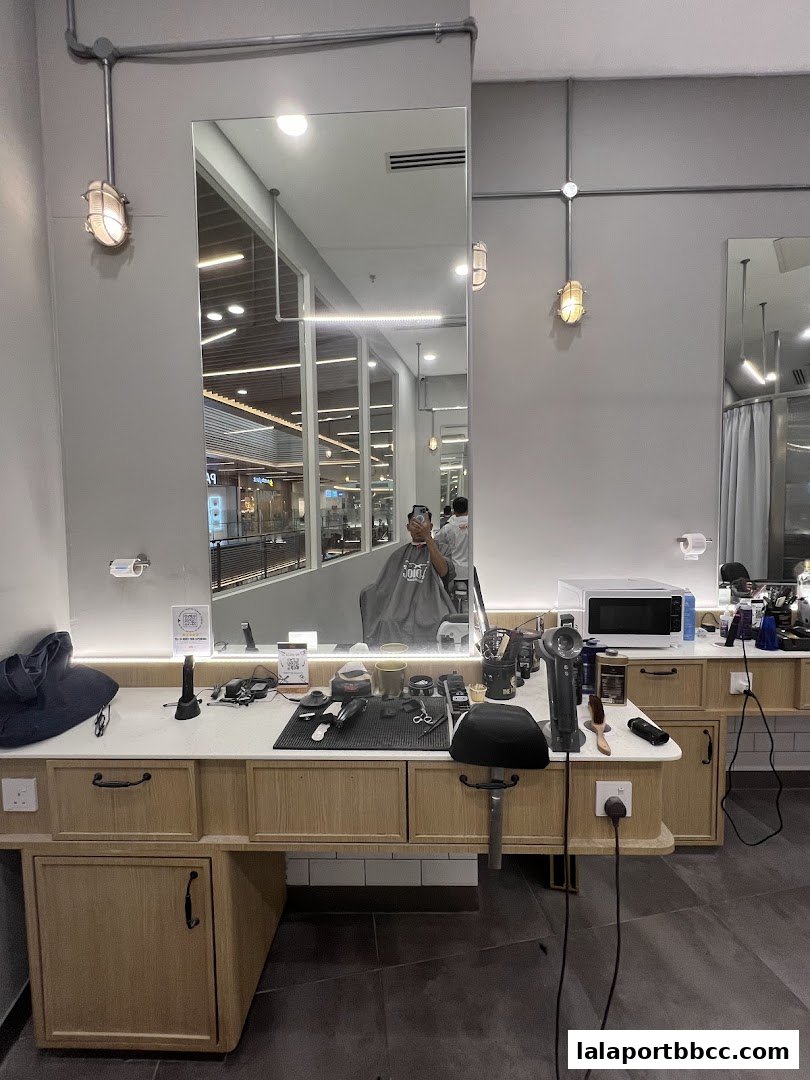 Interior of a modern barbershop with mirrors, barber chairs, and styling tools.