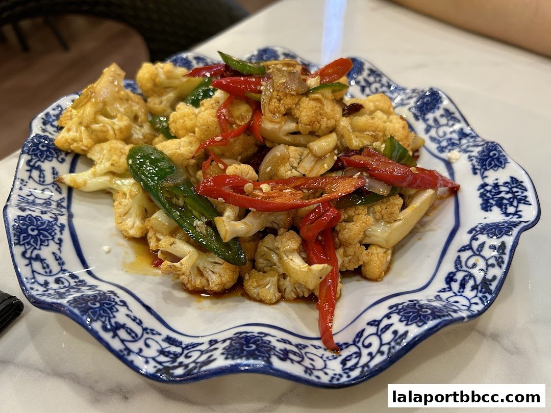 A close-up shot of a delicious stir-fried cauliflower dish with chili peppers.