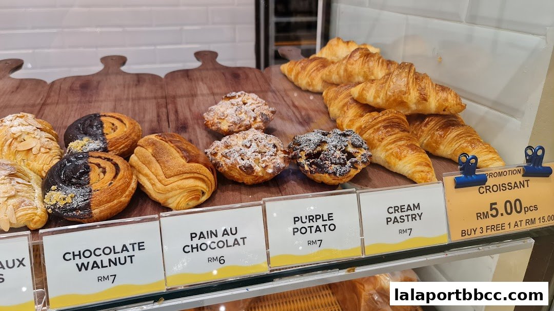 A display of freshly baked pastries including croissants, pain au chocolat, and tarts.