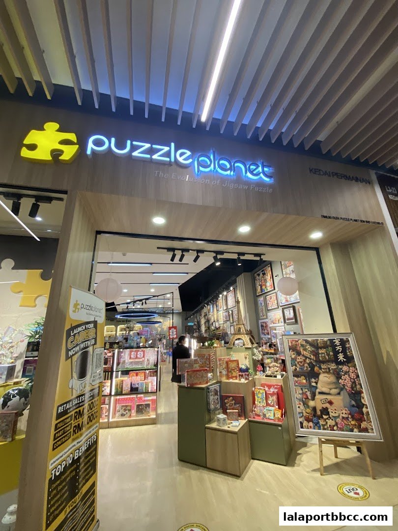 The entrance of Puzzle Planet, a jigsaw puzzle store, showcasing various puzzles and a recruitment banner.