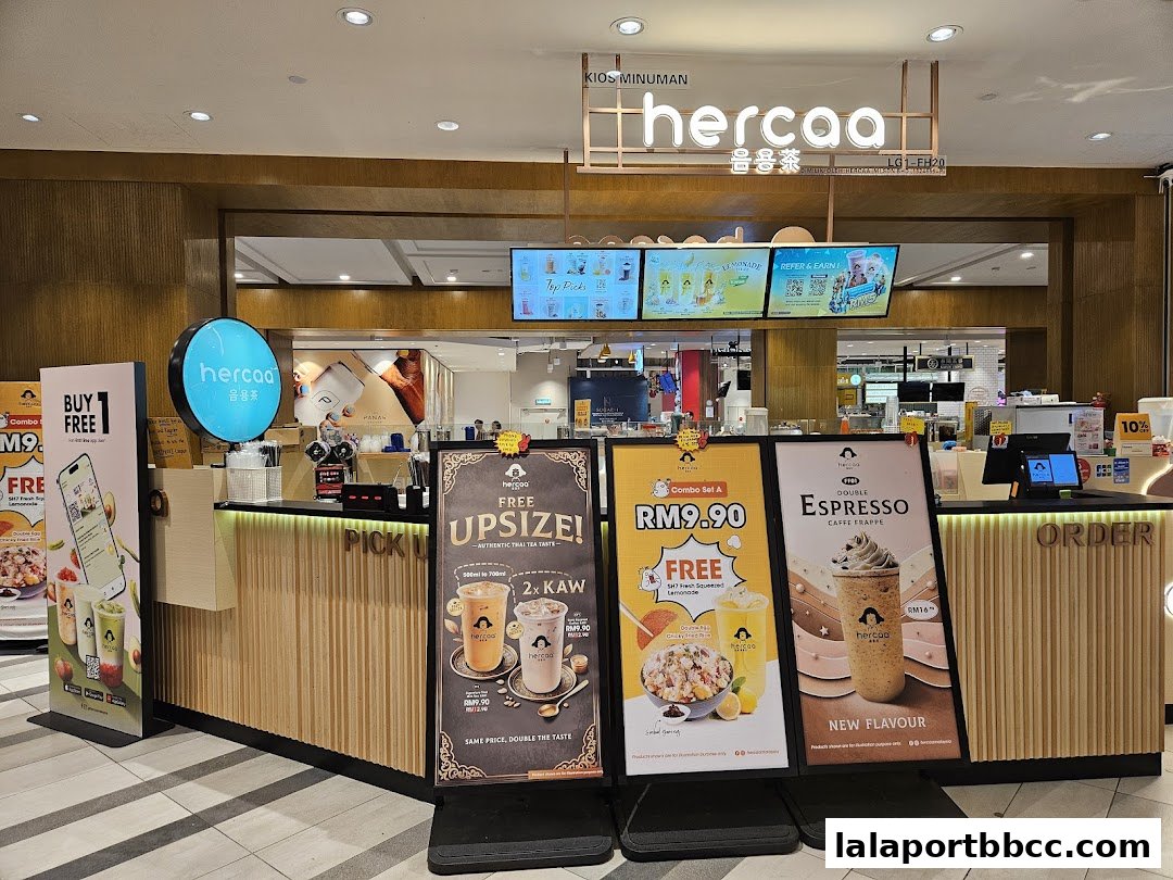 A modern beverage shop counter with promotional displays and menu boards.