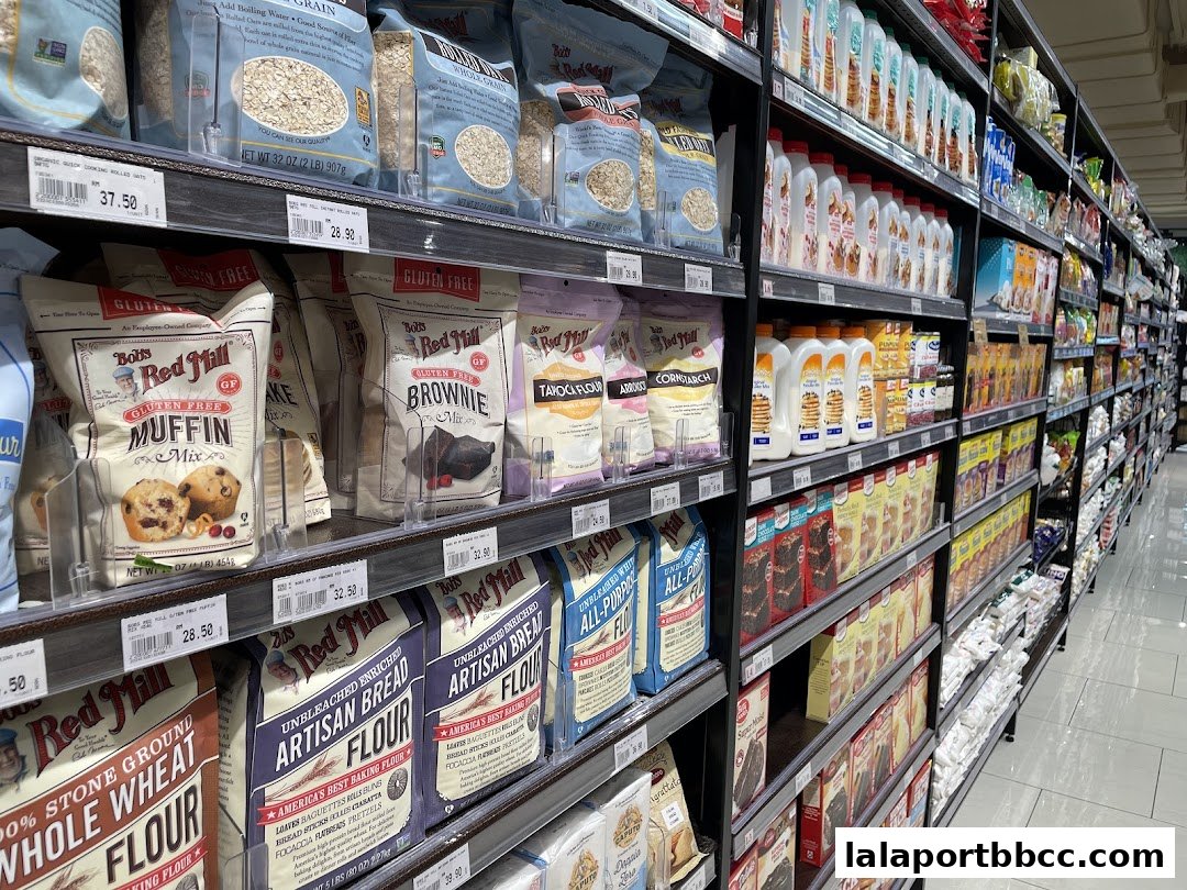 A wide aisle in a grocery store showcasing shelves stocked with various baking ingredients and mixes.