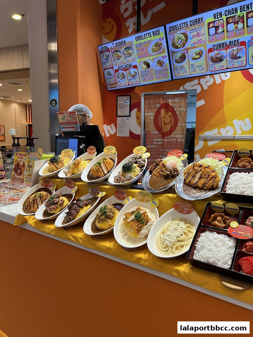 A display of various Japanese curry and rice dishes, with a staff member in the background.