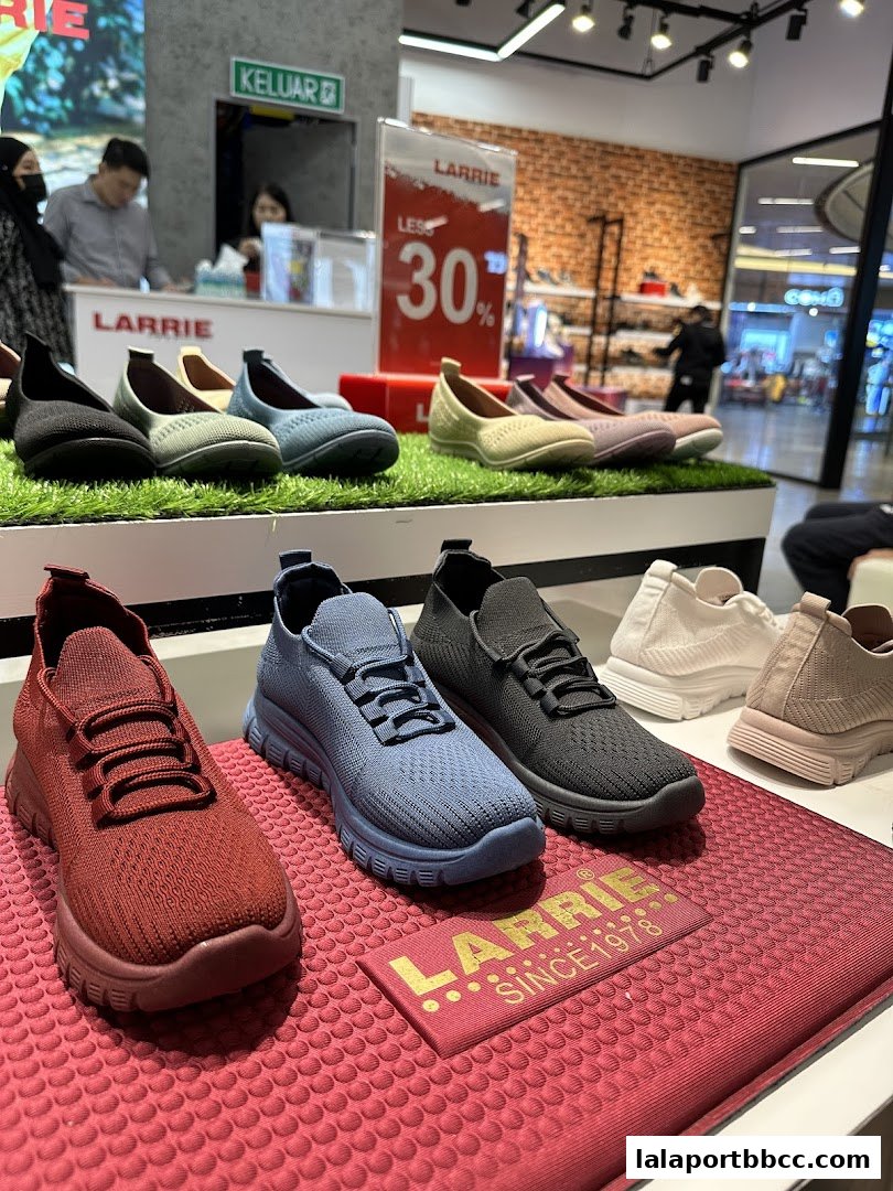 A display of various Larrie brand shoes, including sneakers and flats, with a 30% off sale sign.