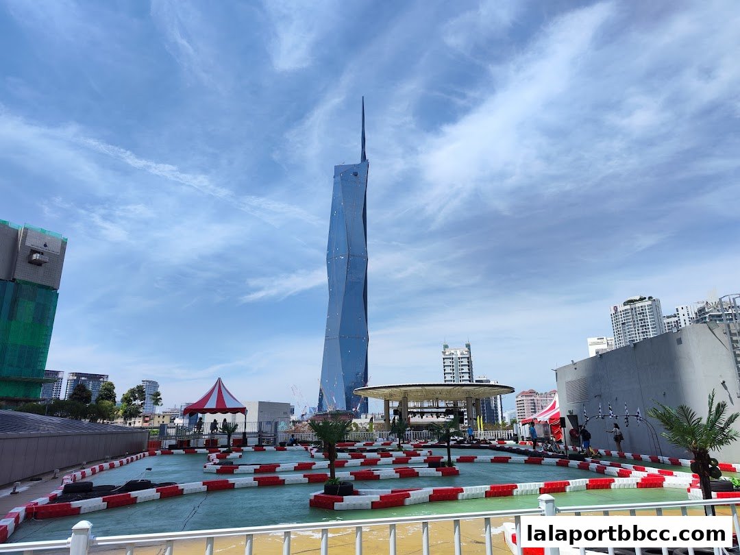 An outdoor go-kart track with a distinctive skyscraper in the background.