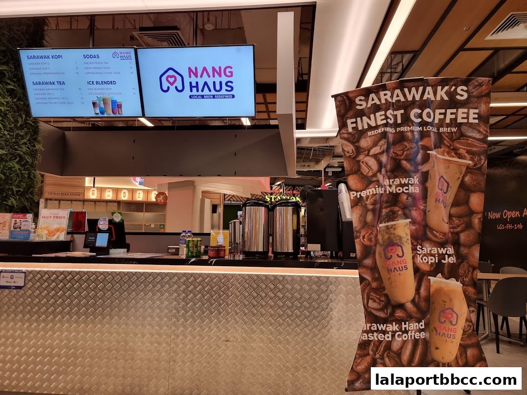 A coffee shop counter with digital menus and a large promotional banner for Sarawak coffee.