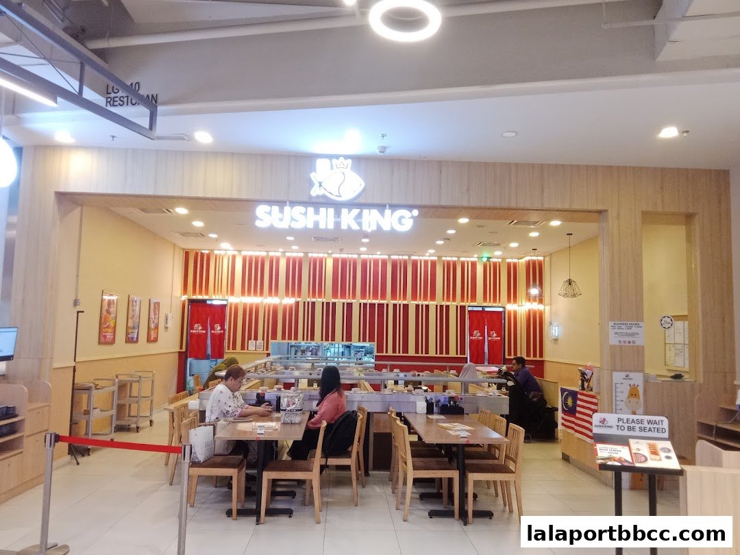 Interior view of Sushi King restaurant with conveyor belt sushi and dining tables.