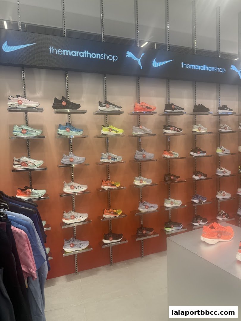 Interior view of The Marathon Shop showcasing a wide selection of athletic shoes on display shelves.