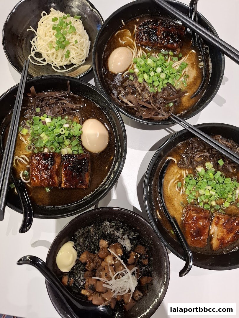 A top-down view of several bowls of ramen and a side dish, beautifully presented.