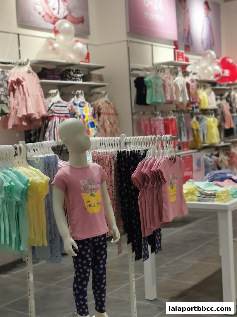 A brightly lit children's clothing store with mannequins and racks of colorful apparel.
