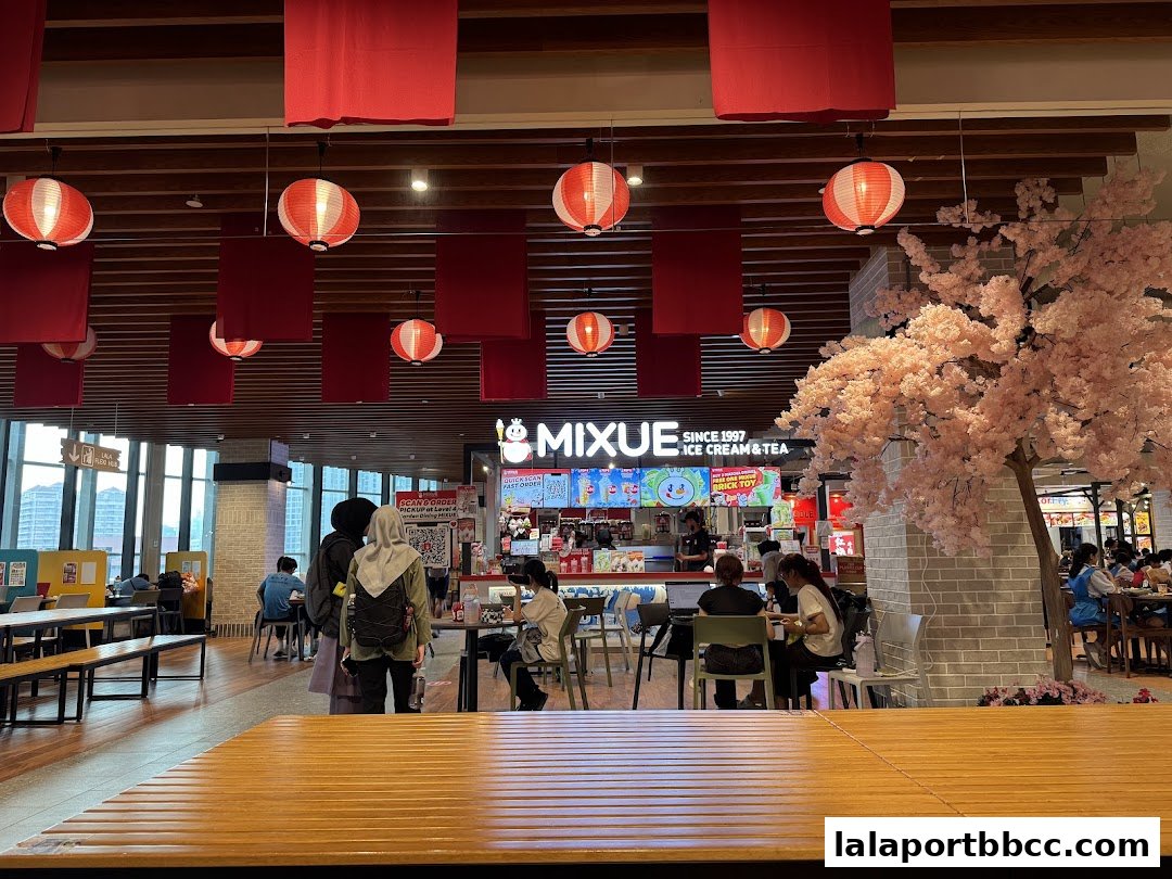 A lively MIXUE ice cream and tea shop with festive red lanterns and a cherry blossom tree.