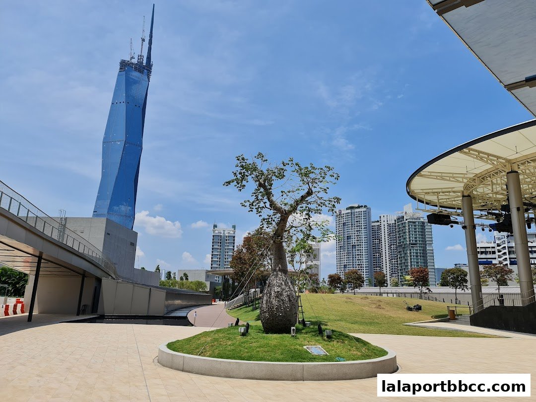 A modern plaza with a distinctive blue skyscraper and an outdoor amphitheater.