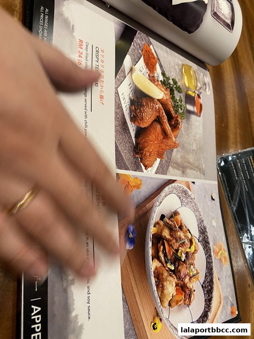 A menu featuring crispy chicken wings and another dish with edible flowers.