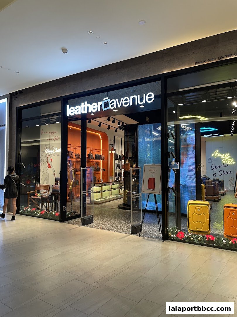 The exterior of the Leather Avenue shop, showcasing bags and luggage, with a festive display.
