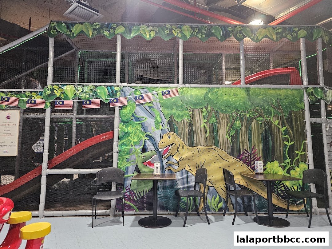 A colorful indoor playground with dinosaur murals and seating areas.