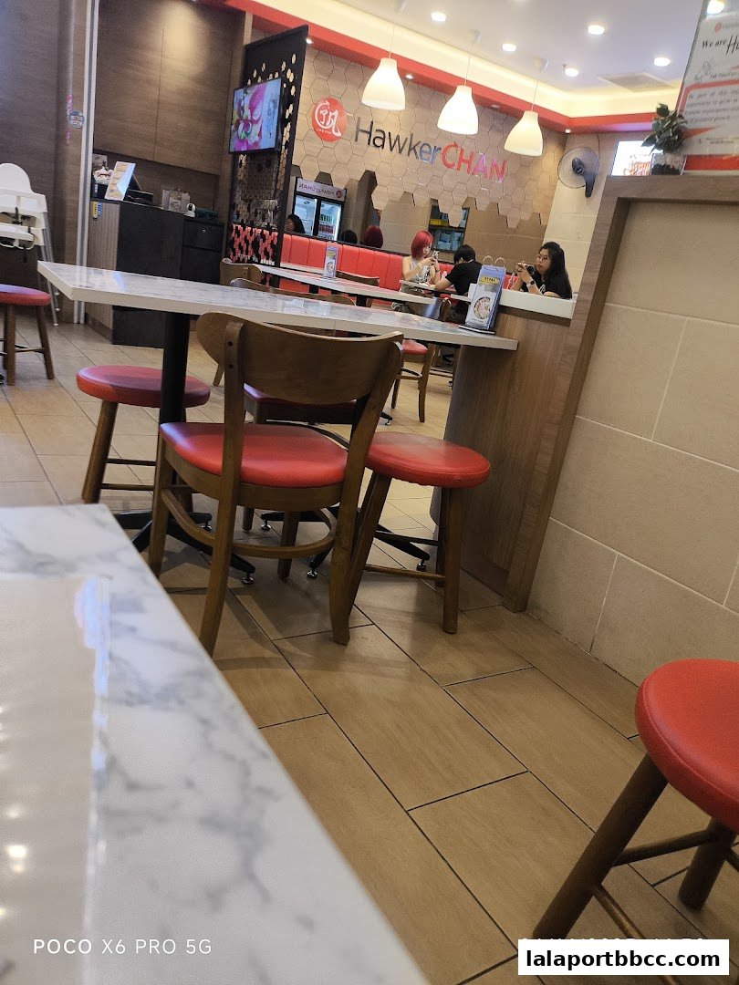 Interior view of Hawker Chan LaLaport BBCC with tables, chairs, and customers dining.