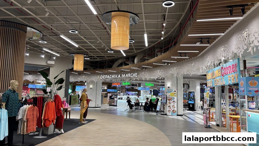 A wide view of a shopping mall interior with various shops and dining areas.
