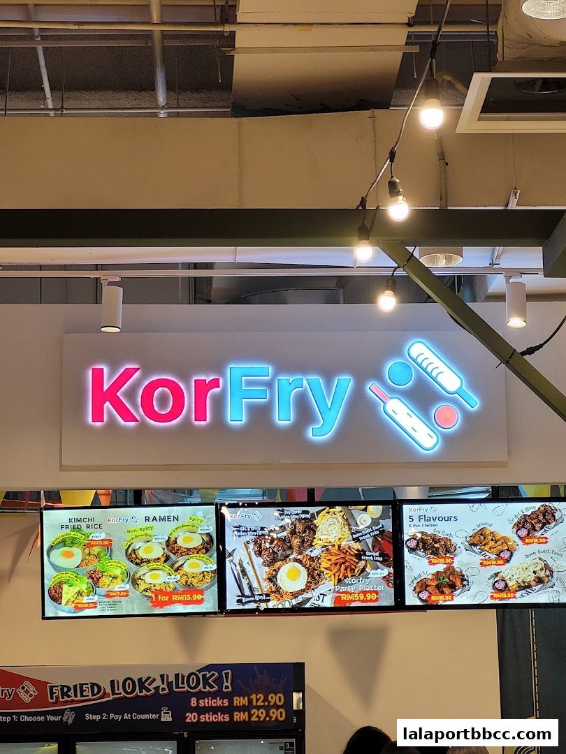 A brightly lit shop front displaying a menu with Korean fried chicken and rice dishes.