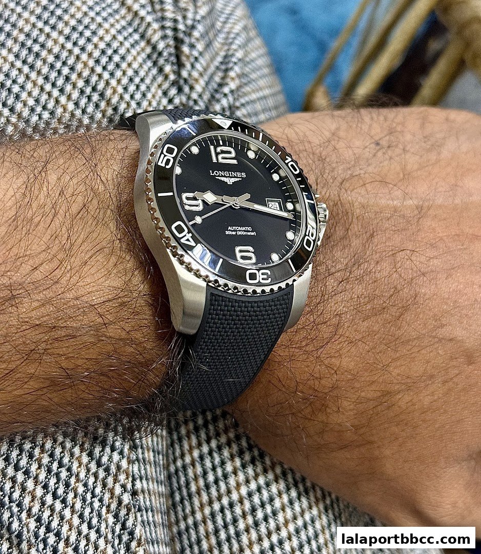 A close-up shot of a Longines automatic watch with a black dial and strap on a person's wrist.
