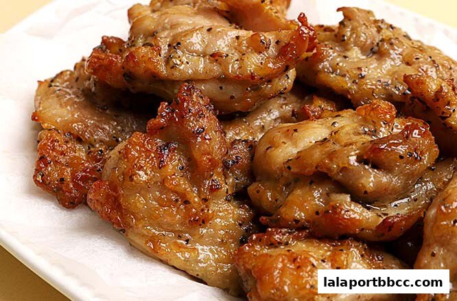 A close-up shot of perfectly grilled chicken pieces seasoned with black pepper.