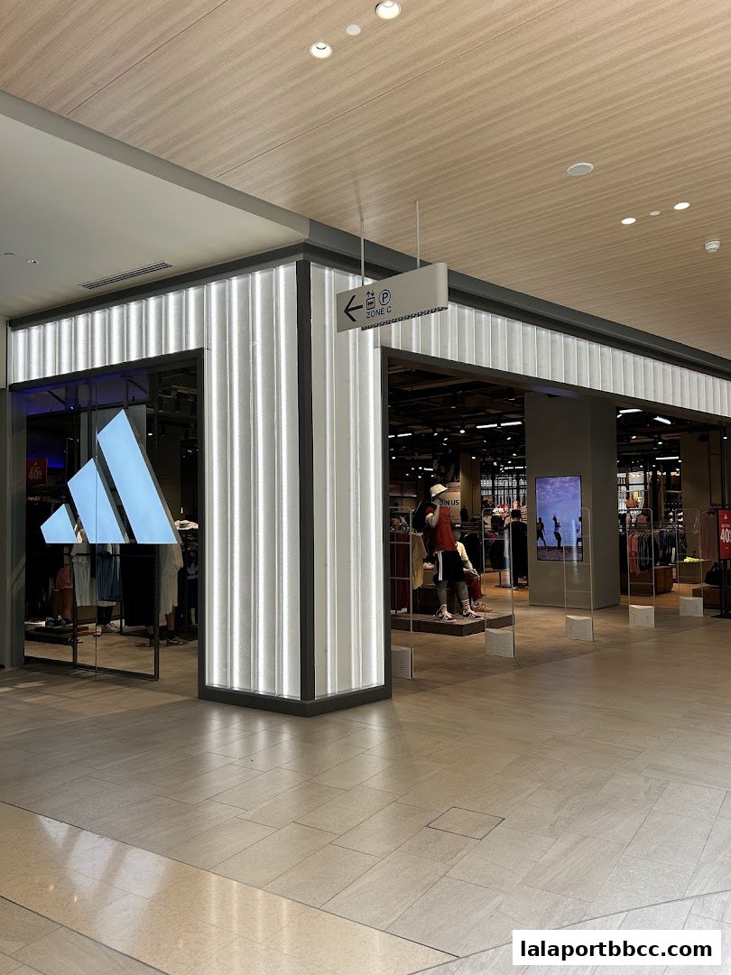 The exterior of an Adidas Originals store with mannequins and merchandise visible inside.