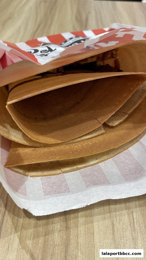 A close-up view of a folded crepe filled with chocolate sauce and possibly other ingredients.