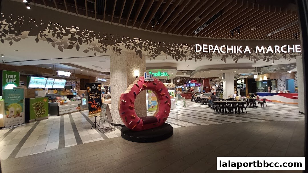 A brightly lit food court area with various eateries and seating.