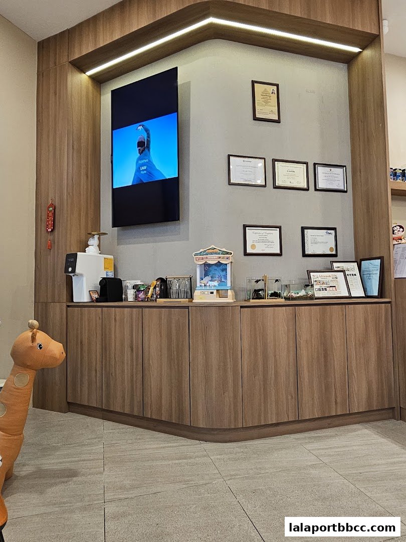 Interior of a dental clinic with a TV screen, certificates, and decorative elements.