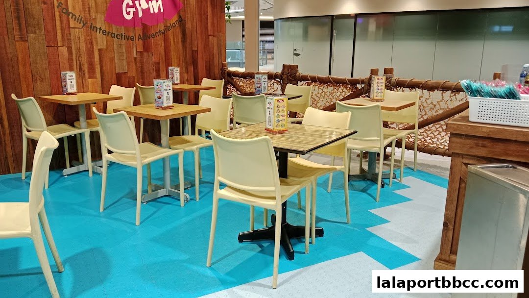 Interior shot of Jungle Gym LaLaport BBCC with tables, chairs, and wooden decor.