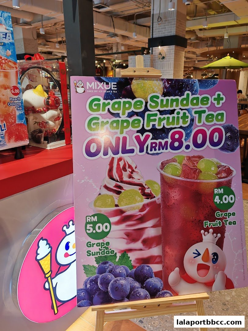 A promotional sign for MIXUE featuring a Grape Sundae and Grape Fruit Tea combo.